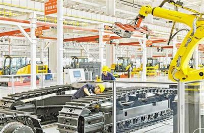 三一重机(重庆)智能制造生产线,工人正在合车线机器人自动涂胶工位作业。(摄于2021年6月30日)张锦辉 摄